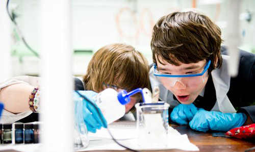 Two primary school children excitedly watching an experiment