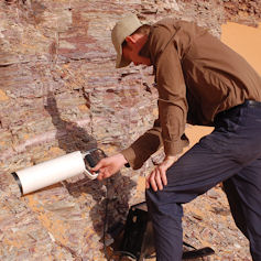 Man using equipment to take a reading from rockface